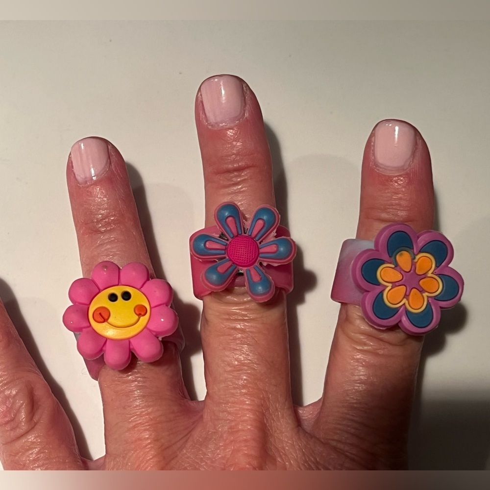 NWOT three silicone flower rings.  The flowers spin on the front of the band.
